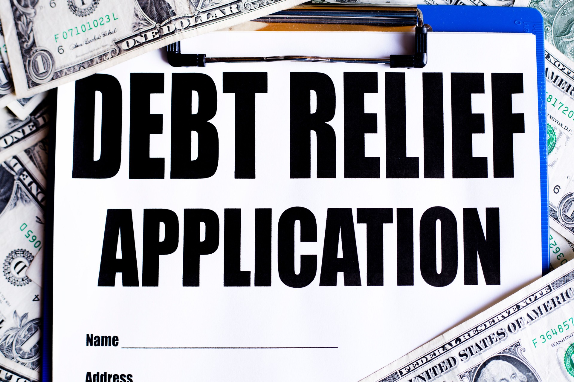 Debt Relief application with  one dollar bills in background.